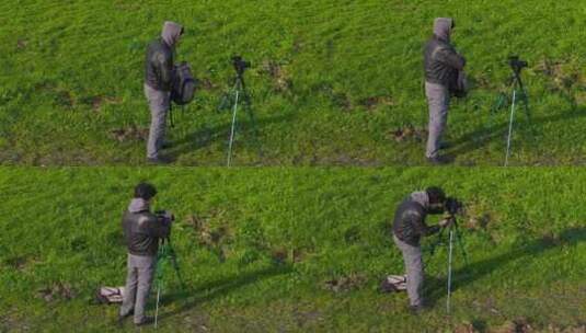 摄影师男子在草地上设置相机三脚架-广角镜高清在线视频素材下载