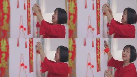 亚洲资深女性为庆祝中国新年装饰她的房子。高清在线视频素材下载