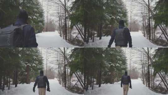 摄影师走在森林里的雪地上高清在线视频素材下载