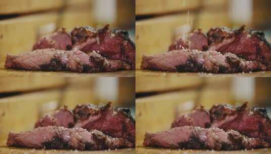 在烤熟的牛肉片上撒上调料的画面高清在线视频素材下载