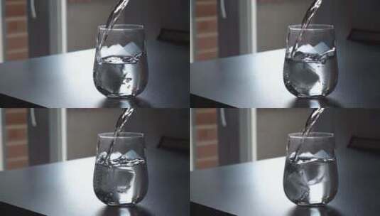 把水倒在装有冰块的杯子里高清在线视频素材下载