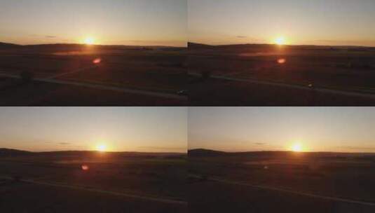 农田上美丽的日落，汽车在乡村公路上行驶，空中高清在线视频素材下载