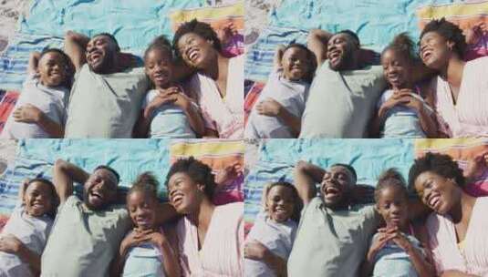 快乐的非裔美国家庭躺在海滩上大笑的视频高清在线视频素材下载