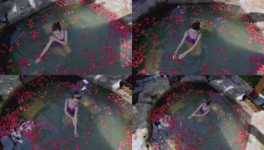 女子在花瓣覆盖的温泉中放松高清在线视频素材下载