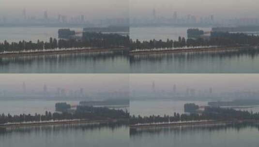 航拍武汉东湖绿道清晨湖面远处城市高清在线视频素材下载