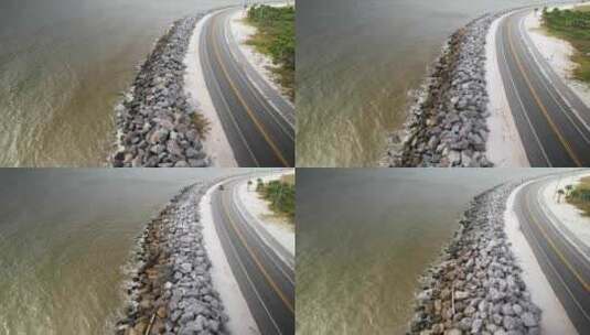 海浪撞击岩石屏障旁的沿海公路高清在线视频素材下载