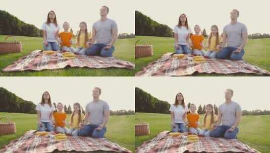 一家四口坐在草地上冥想高清在线视频素材下载