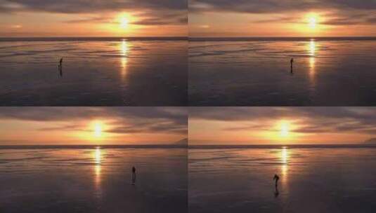 日落时分贝加尔湖冰上溜冰者的剪影。顶部角高清在线视频素材下载