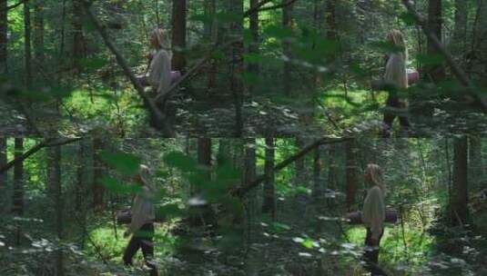 女人拿着瑜伽垫在树林里行走高清在线视频素材下载