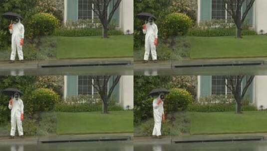 一个穿着危险品服的男人拿着伞穿过街道高清在线视频素材下载