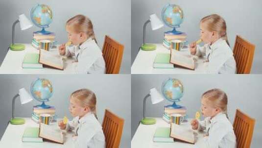 吃着棒棒糖看书的女孩高清在线视频素材下载