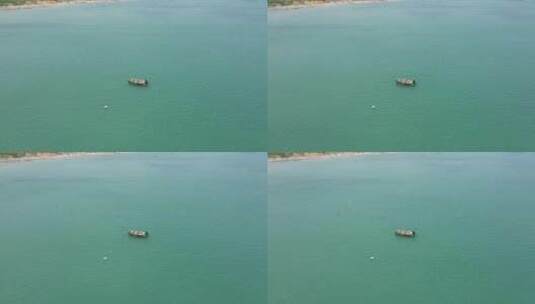 航拍淡蓝色海水中的小渔船高清在线视频素材下载