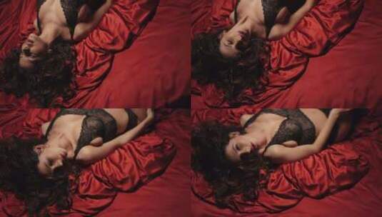 红色丝绸床上的性感女孩相机。迷人的女人放高清在线视频素材下载