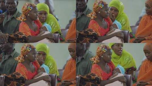 非洲怀抱婴儿的妇女在室内聚集高清在线视频素材下载