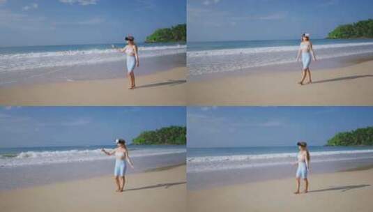 VR耳机中的女人在海滩上探索虚拟热带海浪高清在线视频素材下载