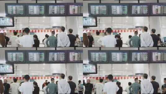 机场接机口航班动态显示屏前旅客背影高清在线视频素材下载
