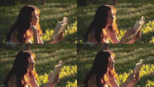 黄昏时分，金色的夕阳下美女在草地上读书高清在线视频素材下载