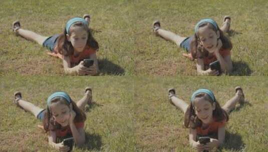 女孩开心的在草地上玩手机高清在线视频素材下载