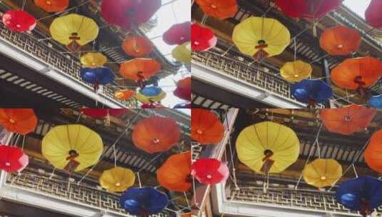 过年春节挂在古楼间的灯笼和红伞高清在线视频素材下载
