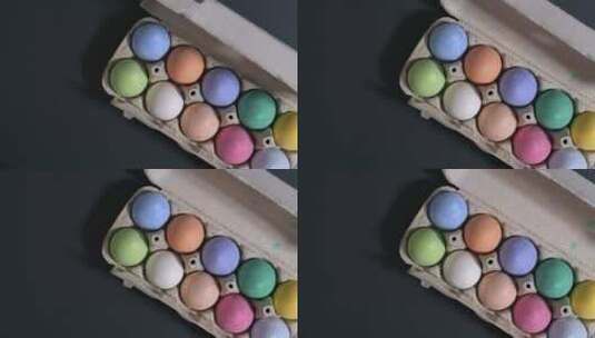 复活节快乐，黑色背景上五颜六色的鸡蛋。一个女人把一盘鸡蛋放在桌子上。高清在线视频素材下载