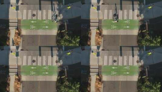 一个骑自行车的人在使用指定的自行车道时通过十字路口的鸟瞰图。高清在线视频素材下载