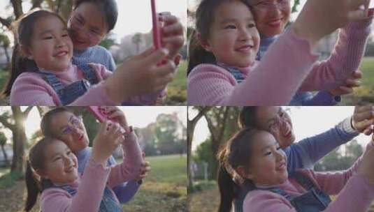 小女孩和妈妈在公园里用手机自拍高清在线视频素材下载