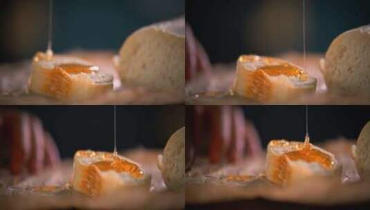 把蜂蜜倒在一块面包上的人高清在线视频素材下载