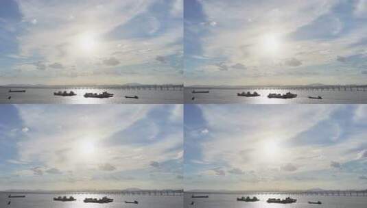 夕阳下的海面船只与桥梁景观航拍阳光下渔船高清在线视频素材下载