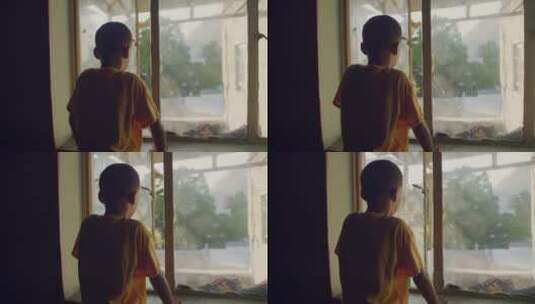 一个男孩站在窗口往下看高清在线视频素材下载