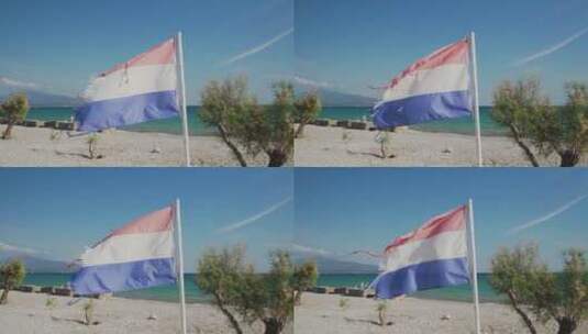 撕裂的红白蓝三色旗帜在海滩上飘扬高清在线视频素材下载