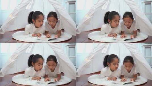 趴在帐篷里看书的两个女孩高清在线视频素材下载