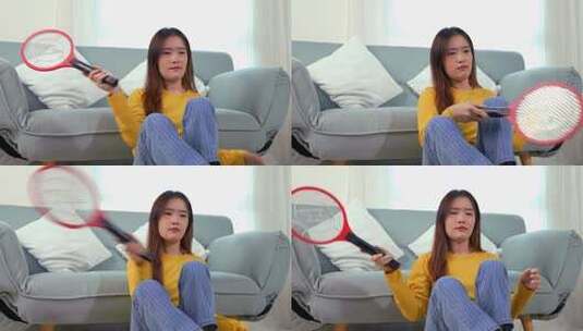 妇女在客厅使用电蚊拍高清在线视频素材下载