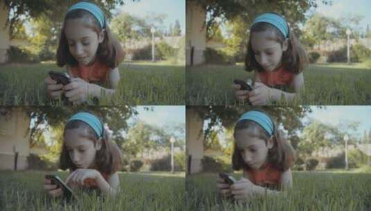 女孩趴在草地上玩手机高清在线视频素材下载