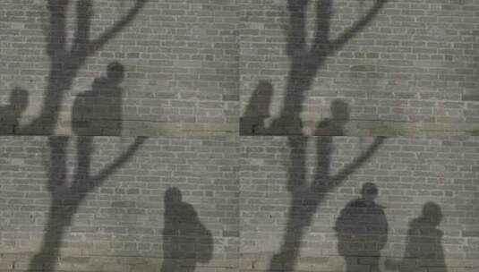 人物行走影子投射在砖墙上高清在线视频素材下载