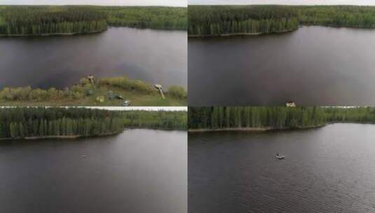 鸟瞰森林环绕的湖泊，两个渔民在船上钓鱼11高清在线视频素材下载