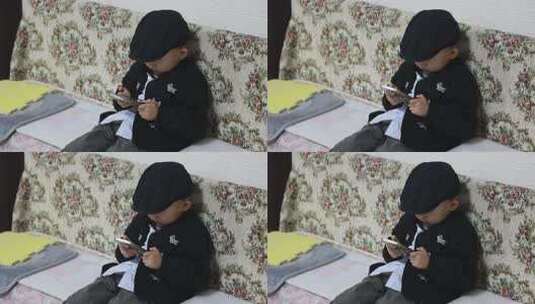 小男孩沙发上玩手机画面高清在线视频素材下载