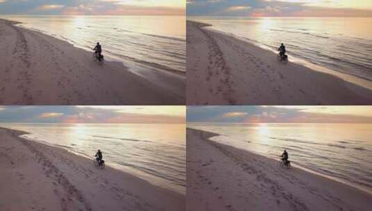 日落时分，一个骑自行车的年轻人在海滩上的空中慢动作镜头。沙滩自行车骑行。高清在线视频素材下载