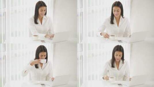 女子坐在办公桌前喝咖啡工作高清在线视频素材下载