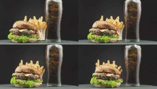 汉堡配薯条和苏打水在黑暗的背景高清在线视频素材下载