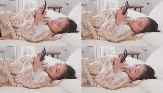 女青年躺在床上看手机高清在线视频素材下载