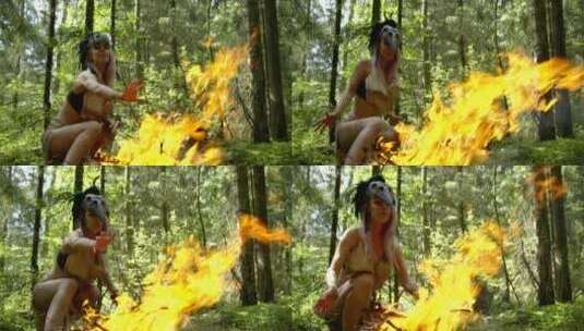 白天，兴奋的女萨满坐在森林里的大型仪式火旁，女人戴着面具高清在线视频素材下载