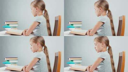 儿童坐在书桌前阅读书籍高清在线视频素材下载