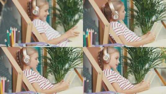 小女孩戴着耳麦看书高清在线视频素材下载