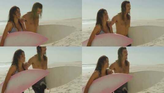 情侣与冲浪板走在沙滩上高清在线视频素材下载