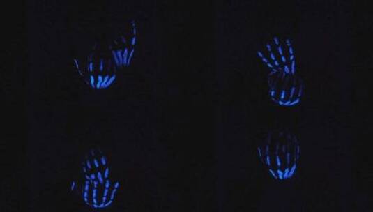 戴着蓝色霓虹灯手套在黑暗中做手势高清在线视频素材下载