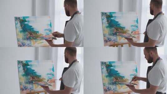 男画家正在用画笔画油画高清在线视频素材下载