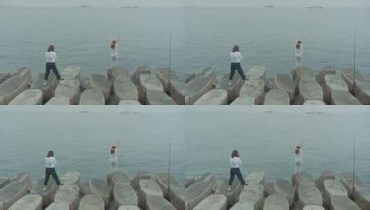 青岛八大峡堤坝 吹海风拍照的女孩高清在线视频素材下载