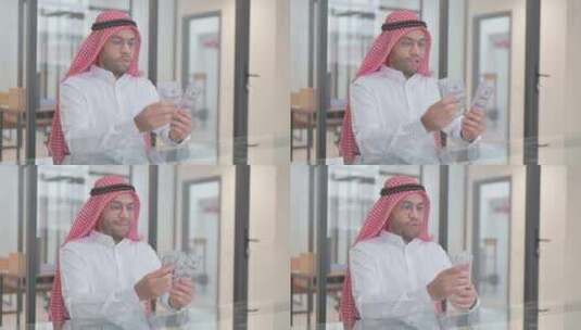年轻的阿拉伯人在工作中数钱高清在线视频素材下载