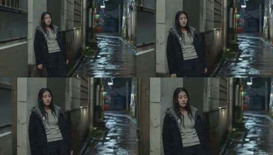 夜晚街头靠墙站立的年轻女子高清在线视频素材下载