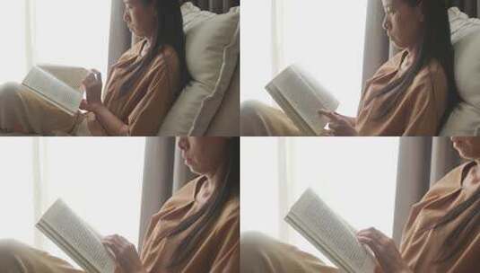 女性室内沙发上阅读书籍高清在线视频素材下载